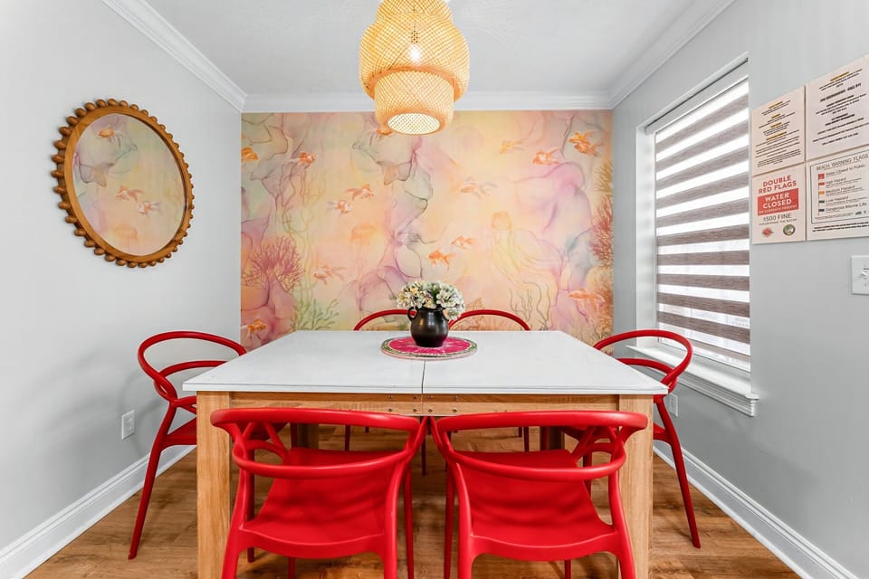 Dine in style with ocean vibes, bold red chairs & cozy lighting!