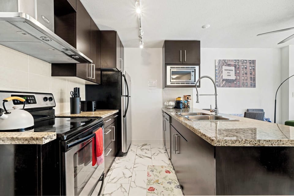 Prepare gourmet meals in a fully equipped kitchen featuring granite countertops, stainless steel appliances, and a full-sized oven. Perfect for long-term stays, this kitchen includes a kettle, toaster, and all the cookware you need.