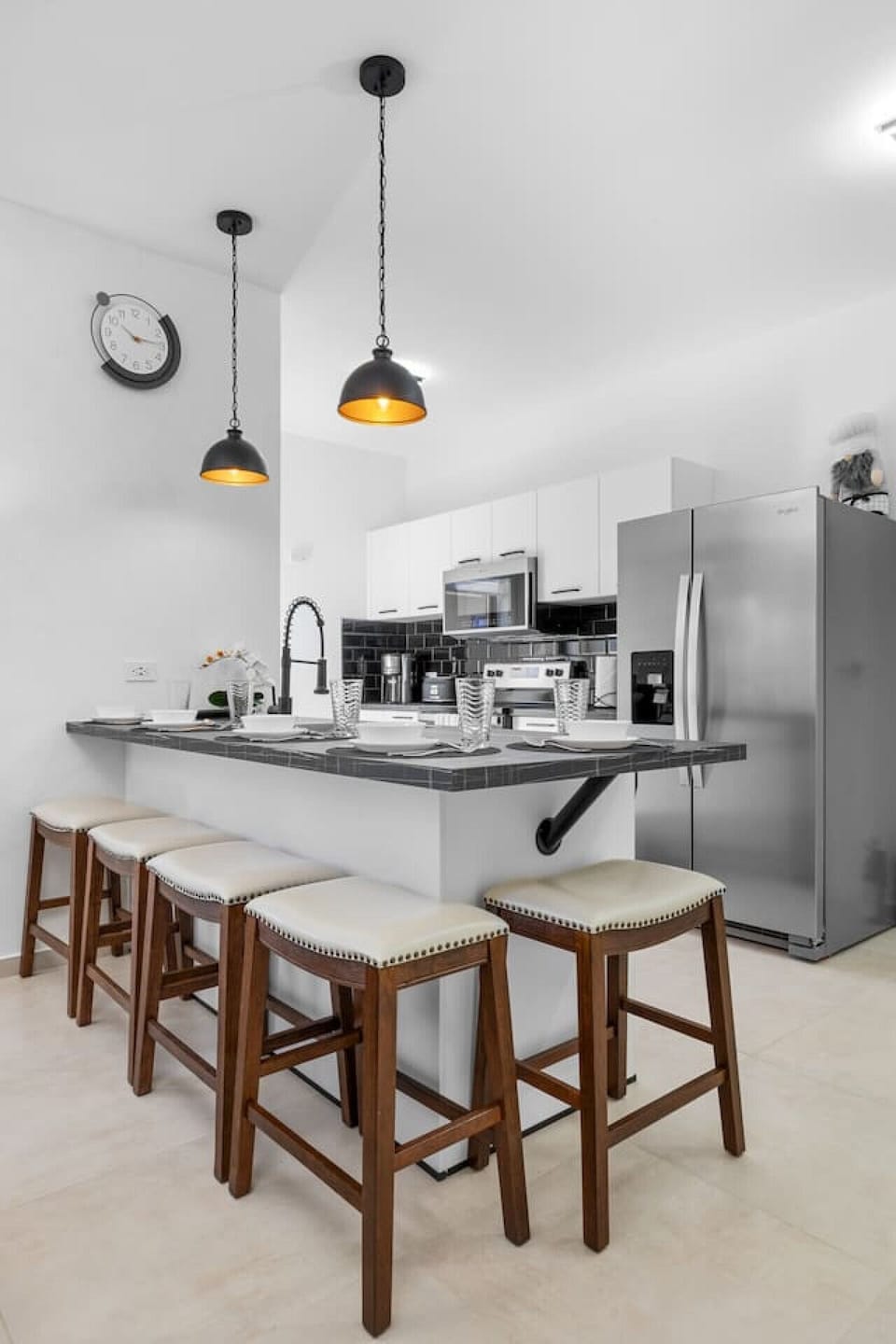 Cook and entertain in this modern kitchen with sleek stainless steel appliances, a spacious island, and stylish pendant lights. The perfect setup for preparing meals or enjoying casual dining with friends.