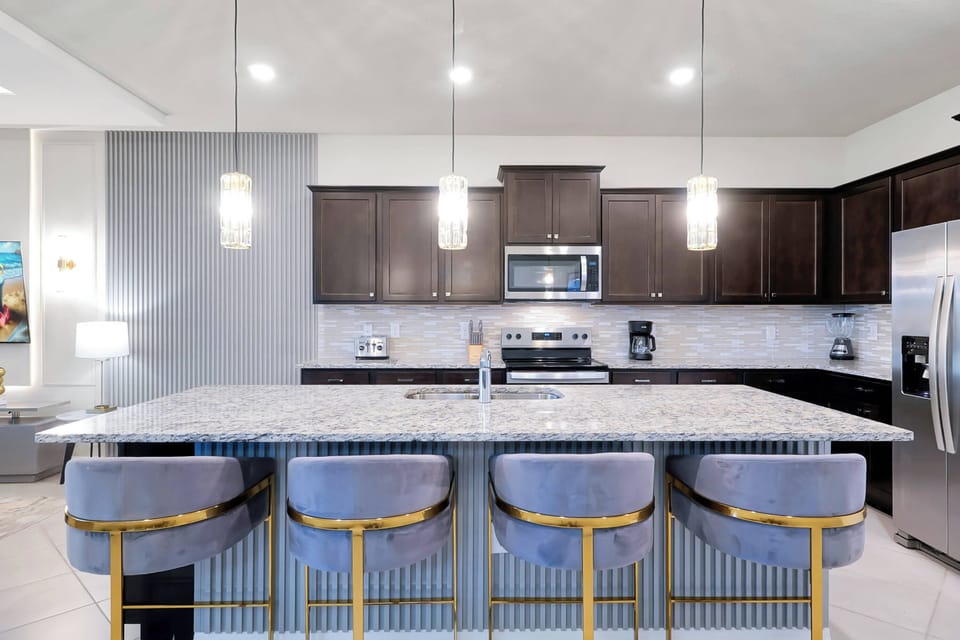 Experience culinary delight in a sleek kitchen featuring dark wood cabinetry and a stunning granite island. The chic bar stools invite casual conversations, while pendant lighting casts a warm glow over your cooking adventures.