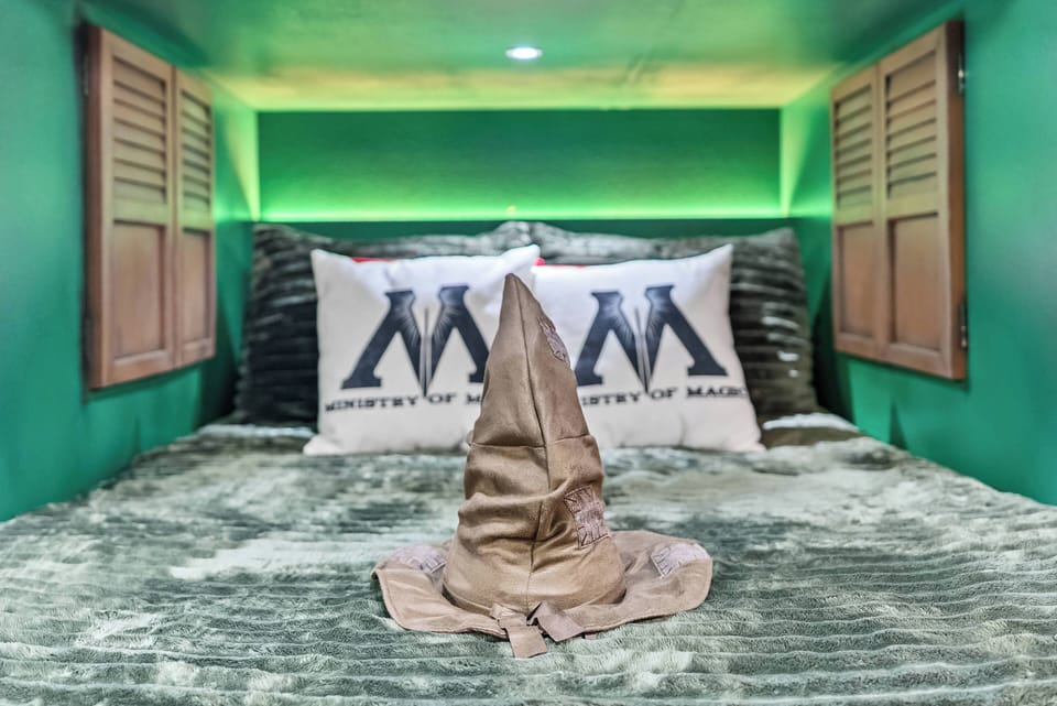 Experience a cozy hideaway with a rich emerald backdrop and plush bedding, highlighted by stylish throw pillows. The soft textures and warm lighting create an inviting atmosphere, perfect for unwinding after a day of adventure.