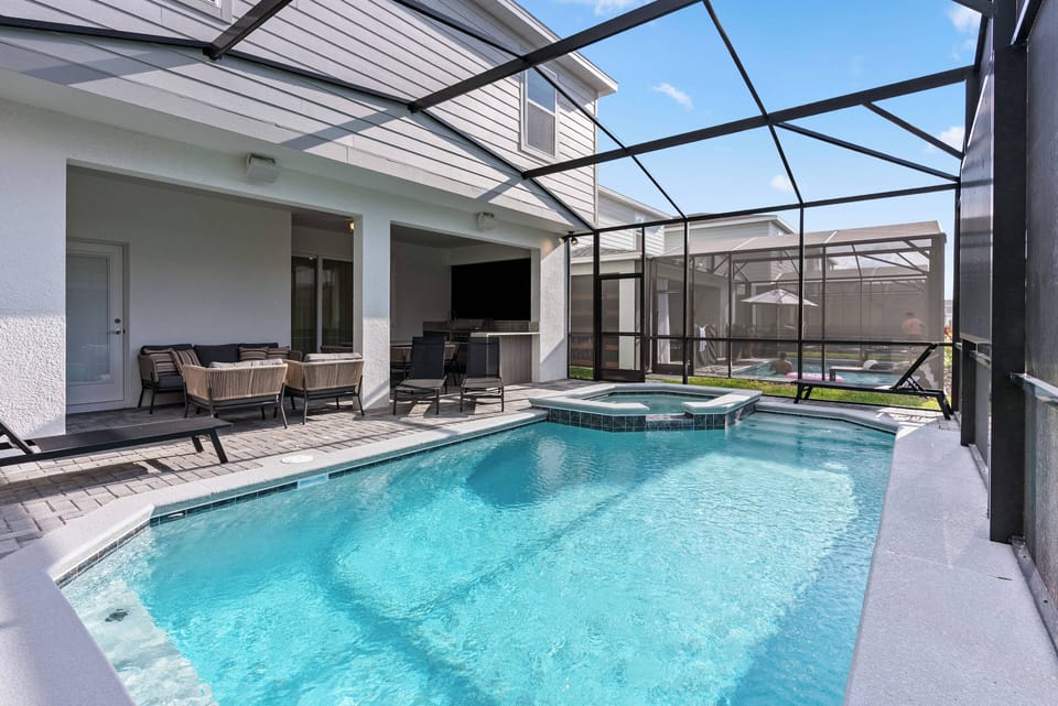Step outside to your private oasis, where a sparkling pool glistens under the sun, framed by sleek patio furniture. Enjoy the comfort of lounging in style, with a covered area perfect for unwinding after a refreshing dip.