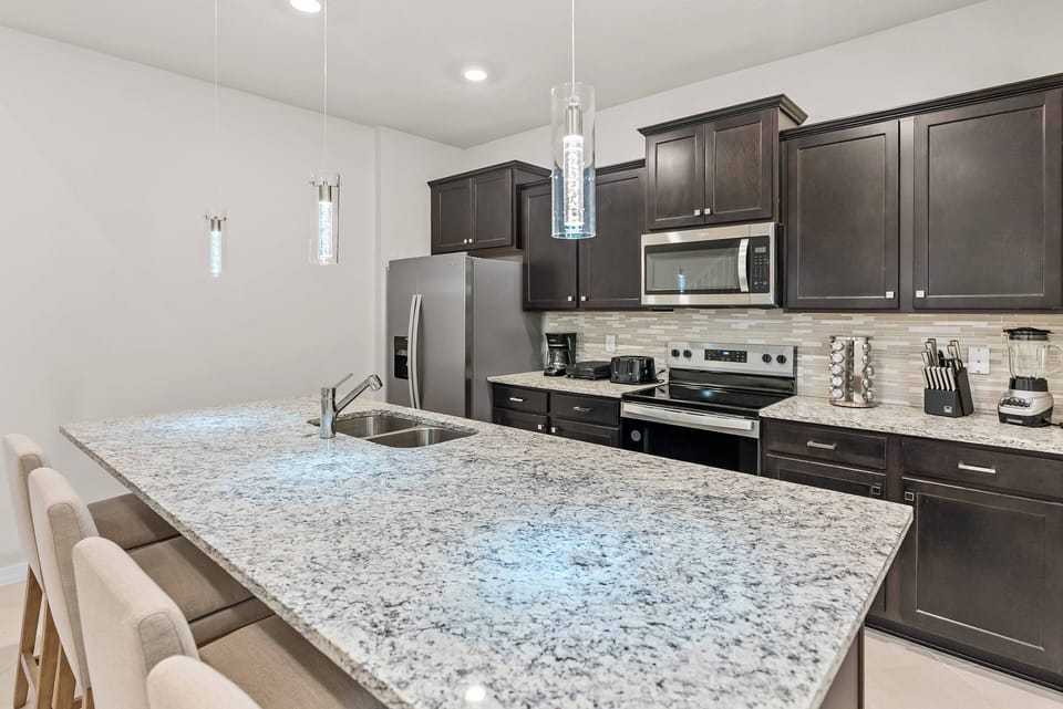 Enjoy a chic kitchen featuring dark cabinets and light granite countertops. The roomy island encourages relaxed conversations, and modern appliances make your culinary adventures both stylish and convenient.