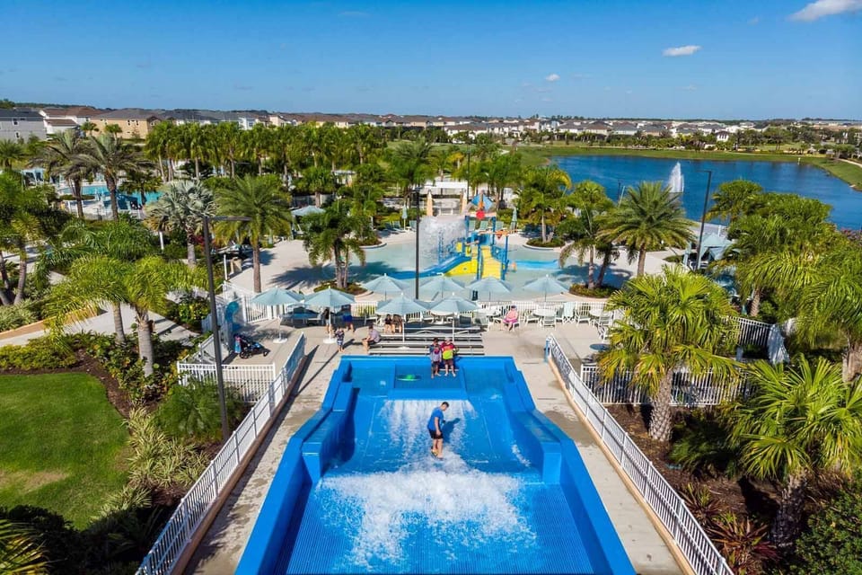Experience the thrill from your balcony, overlooking a vibrant water park with a wave pool and playful areas surrounded by palm trees. Relax and enjoy the sunny skies and sparkling blue waters that create a perfect getaway.