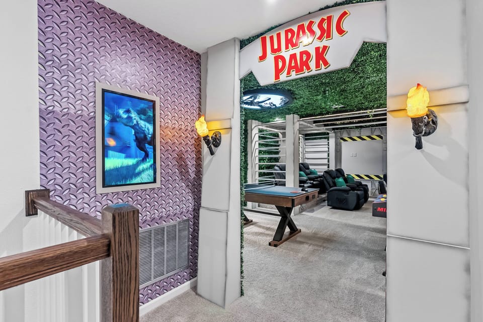 Welcome to a whimsical adventure! This vibrant entryway with a Jurassic Park sign and textured purple wall invites you to a fun-filled space where unforgettable moments await. Enjoy the unique entertainment that lies ahead!