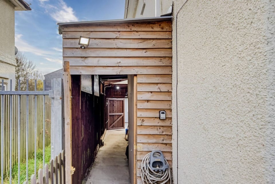Side entrance from the front and car park of the house. The lockbox to the wall