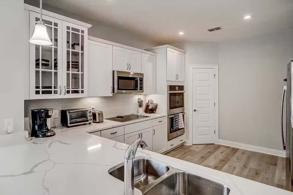 A sleek, modern kitchen equipped with white cabinetry and stainless steel appliances.