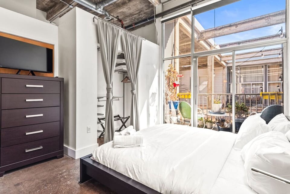 King size bed in main bedroom with soaring windows (and blackout shades)