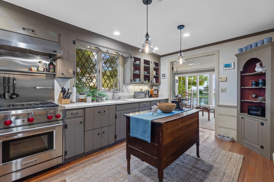 Gourmet kitchen with Wolf Sub-Zero appliances and antique French baker's table