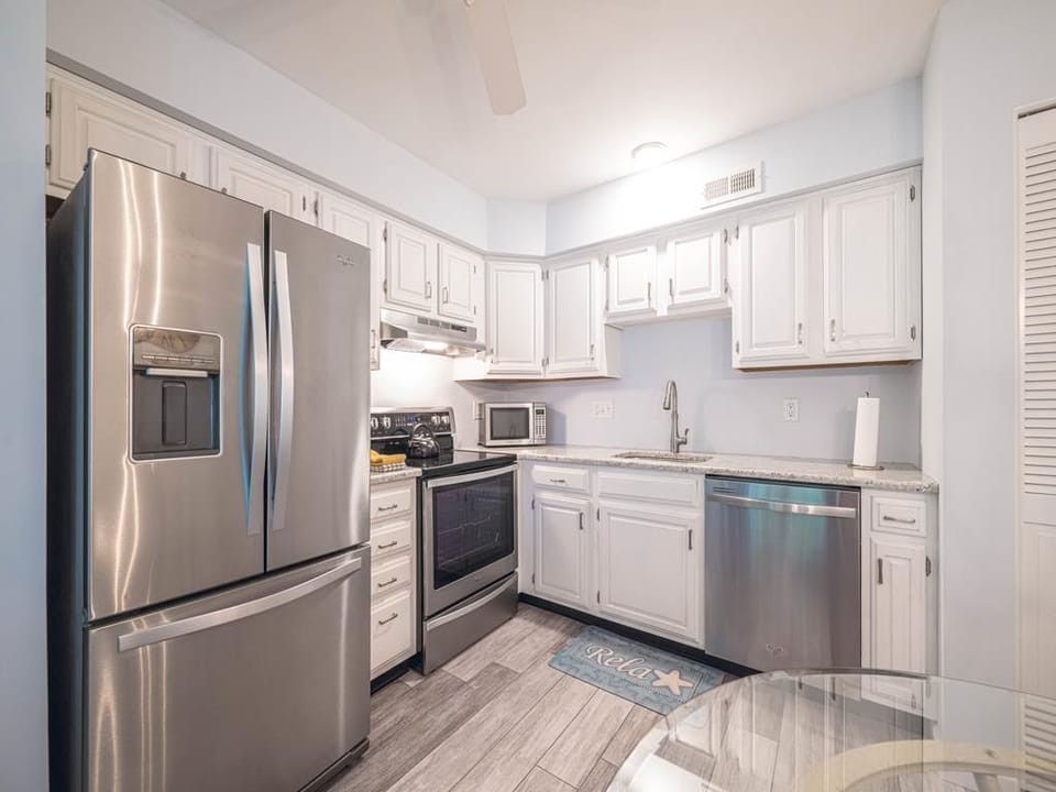 Sleek kitchen with stainless steel appliances and ample storage space.Stainless steel appliances and white cabinetry give a sleek, updated feel.