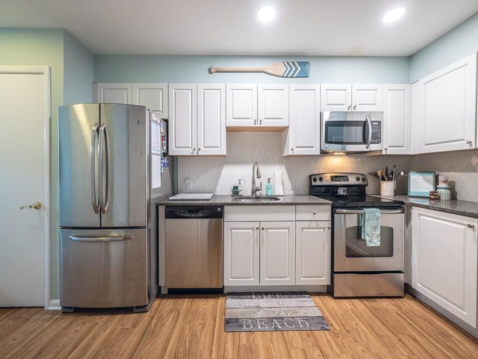 Fully equipped kitchen with stainless steel appliances, ample cabinetry, and modern finishes.