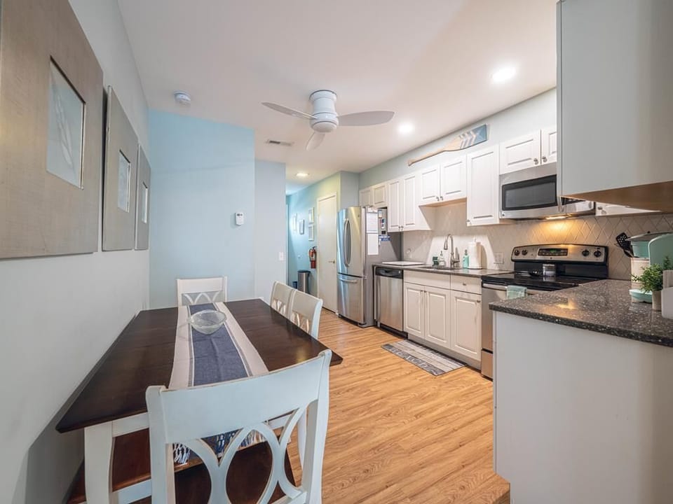 Bright and modern kitchen with stainless steel appliances, ample counter space, and a charming dining area.