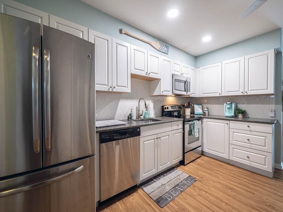 Fully equipped kitchen with stainless steel appliances, ample cabinetry, and modern finishes.
