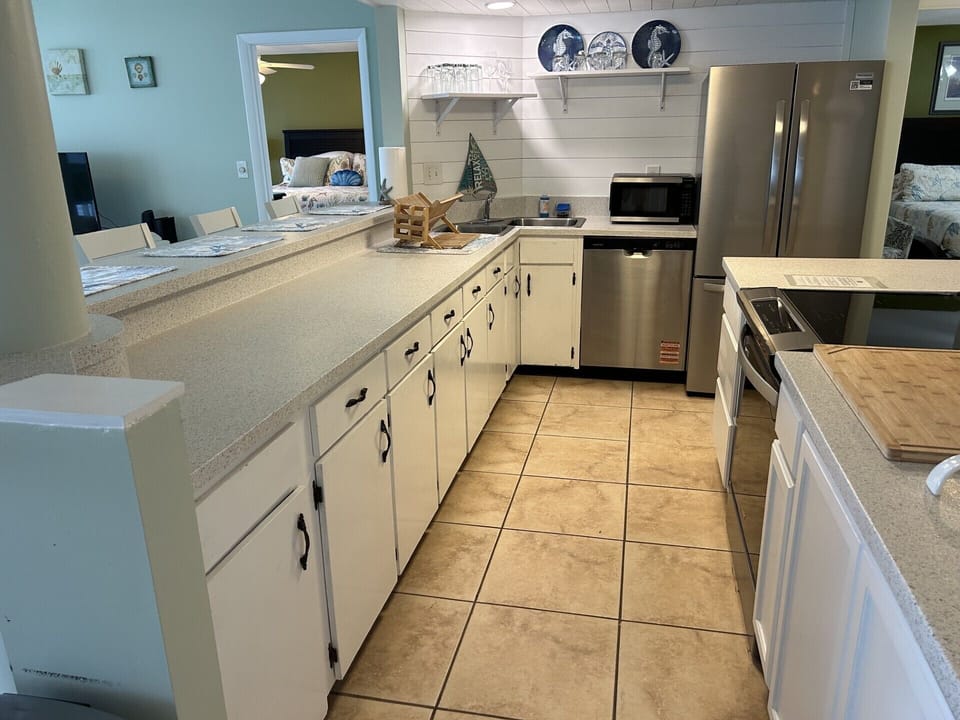 Kitchen with new appliances, countertop, bar stools and newly painted. 