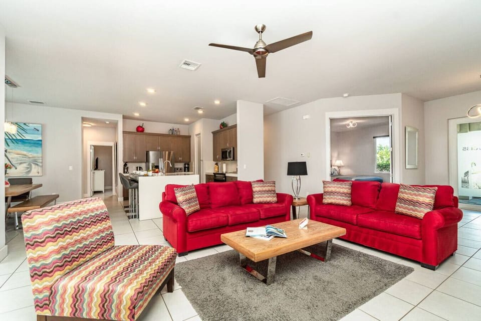 Spacious living area with vibrant red sofas and modern decor, perfect for relaxing after a day of exploring.