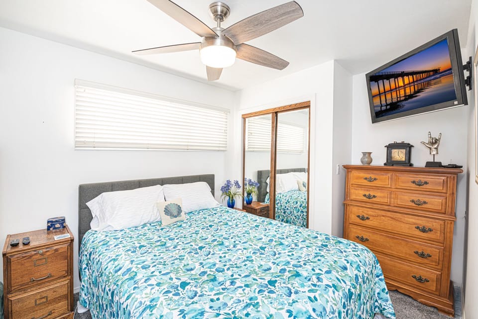 Inviting guest bedroom with queen-size bed and a calm coastal ambiance
                