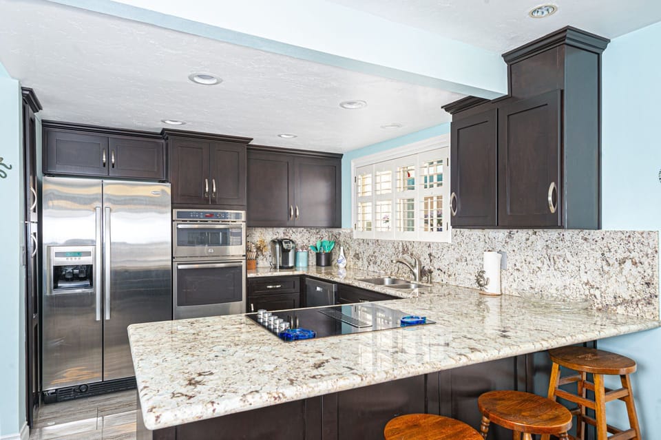 Open-concept kitchen with expansive island, perfect for gathering and entertaining
                
