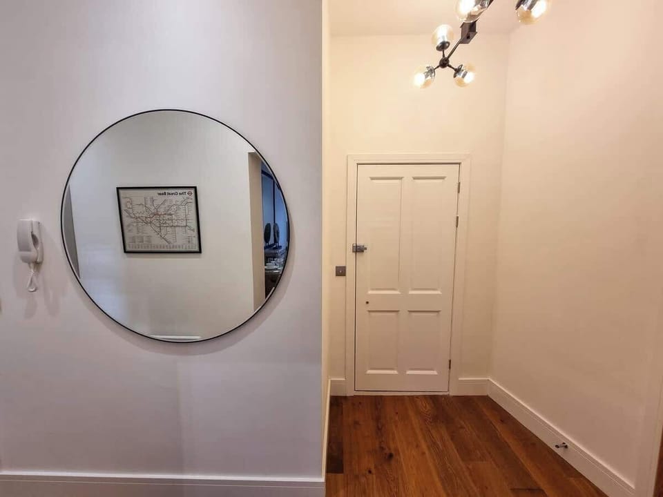 Warm, welcoming hallway with wooden floors and thoughtful details throughout, guests say the apartment feels more like a boutique hotel than a rental
