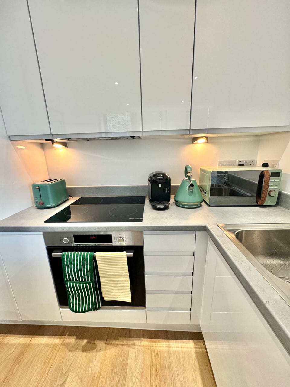 Sleek white kitchen with plenty of worktop space and all the essentials for preparing meals during your stay