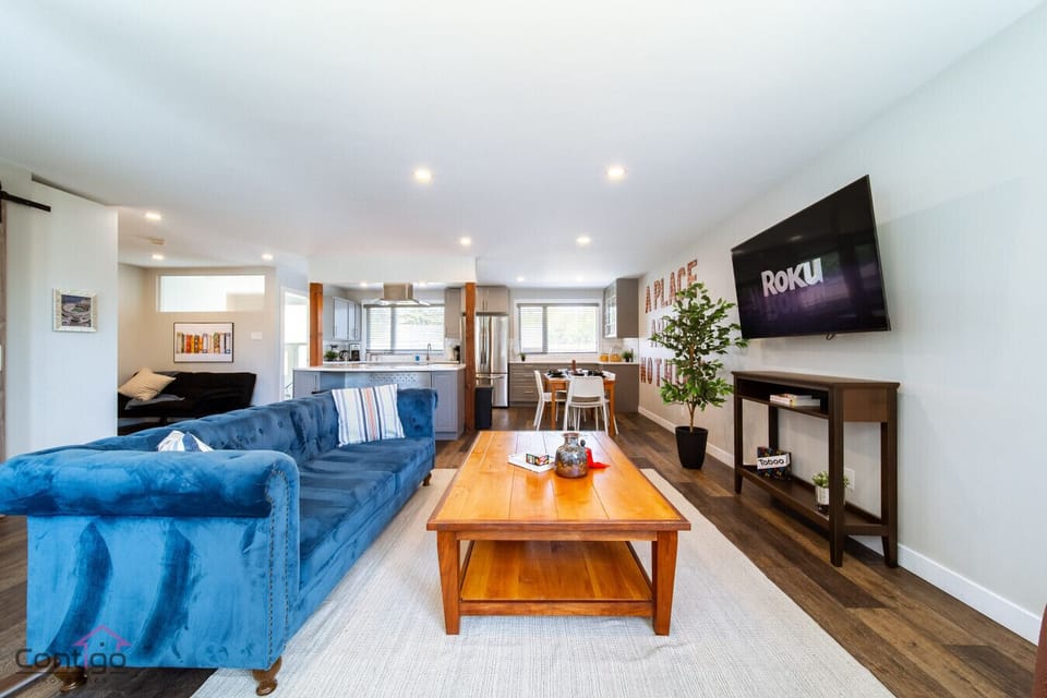 Spacious open-concept living room with Roku TV, plush seating, and easy flow into the modern kitchen, perfect for relaxing or entertaining.