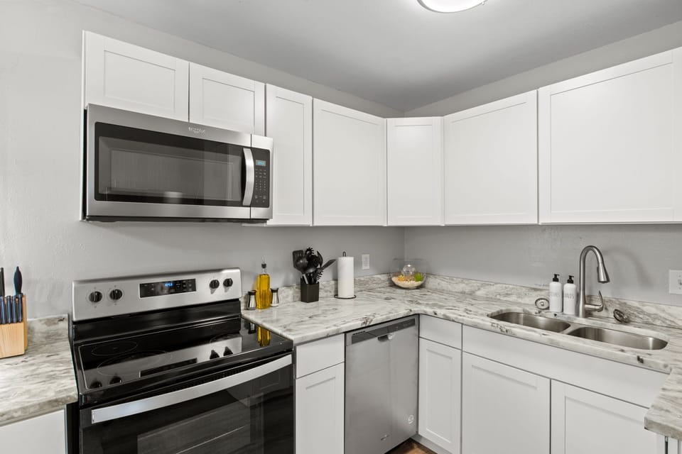 kitchen with microwave, stove, oven, and olive oil
