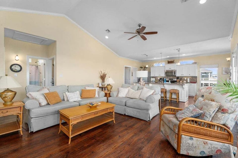 Open-concept beach house interior with cozy seating, dining space, and coastal décor ideal for entertaining guests during Gulf Coast vacations.