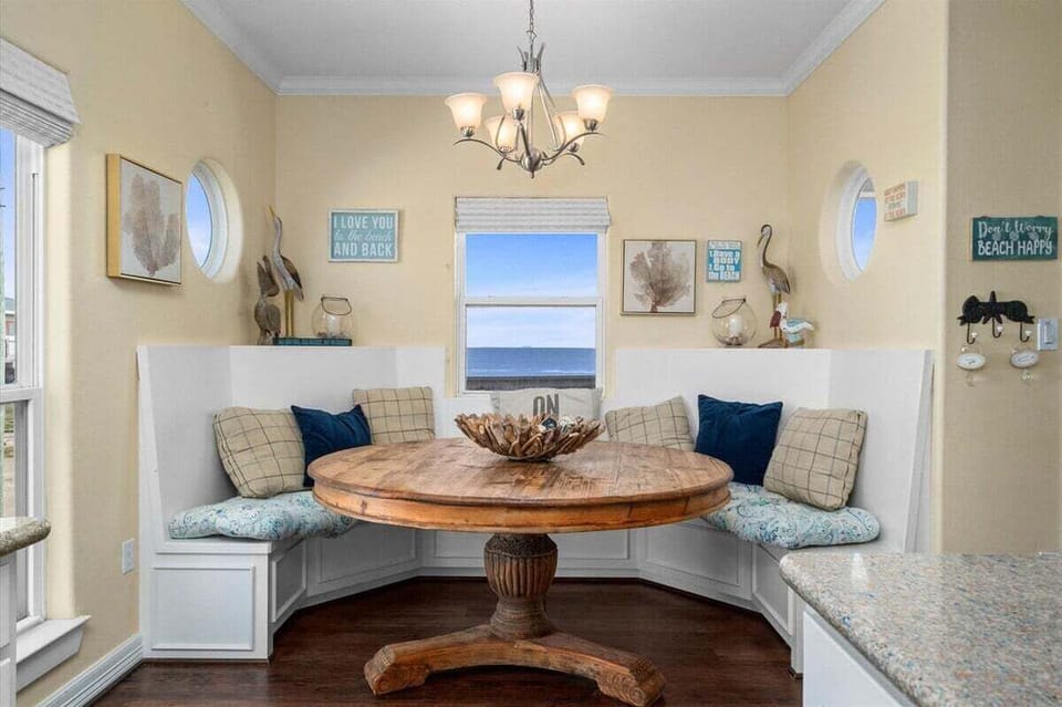 Cozy breakfast nook with built-in seating, coastal décor, and natural light creating the perfect dining space for family beach vacations.