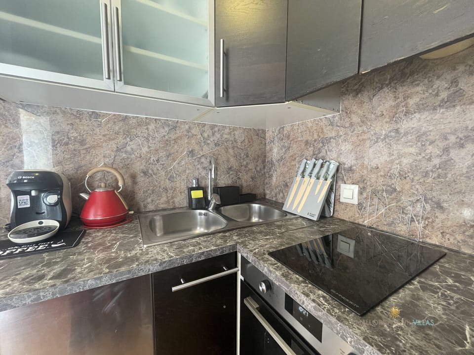 Kitchen with ceramic hob, sink and coffee maker