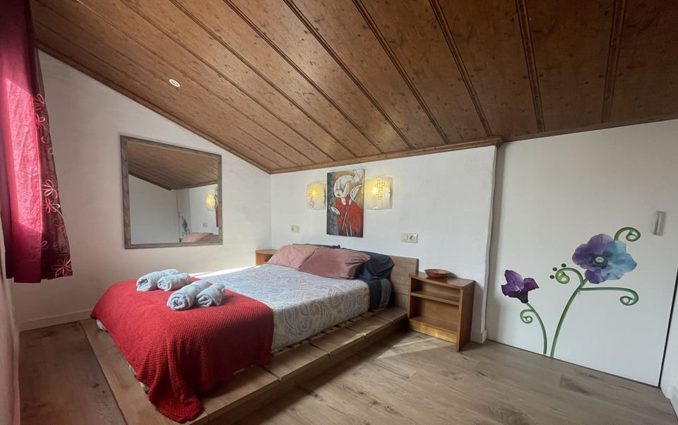 Upstairs bedroom with double bed and wall decor