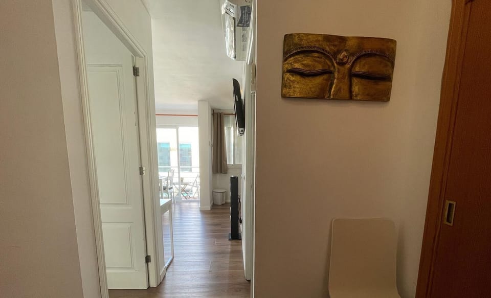 Cozy hallway with wooden flooring and elegant décor, connecting the rooms of the apartment and leading to a bright living area with balcony access.