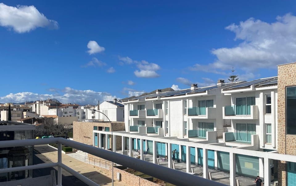 View from the balcony overlooking a modern building and quiet residential area.