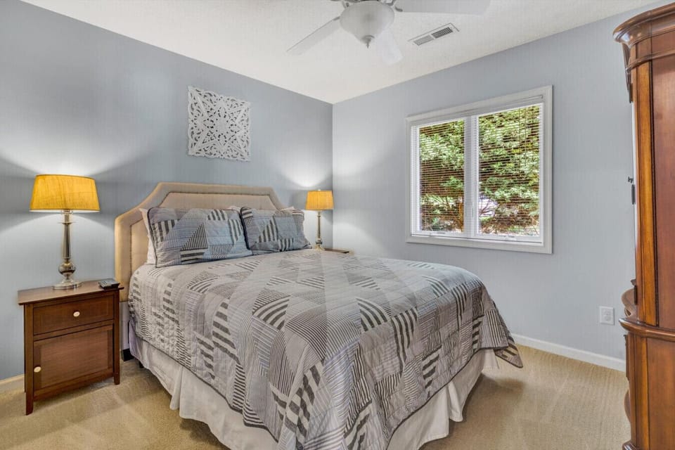 Queen bedroom combines comfort and charm with cozy bedding and tasteful decor.