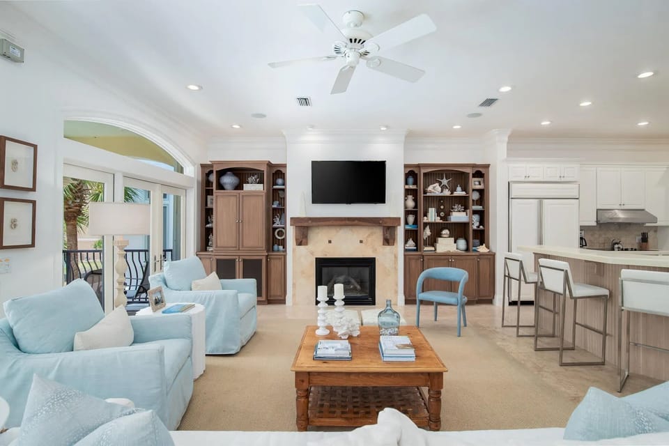 Your open-plan living space blends comfort and elegance, featuring plush seating, a cozy fireplace, and seamless kitchen connection.