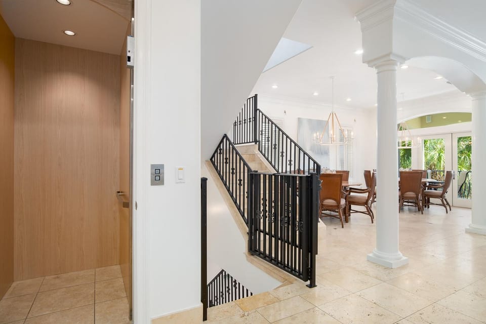Elegant open-plan living with soaring ceilings and graceful columns creates your perfect home base for tropical relaxation.