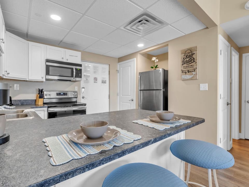 Your fully equipped kitchen awaits with granite counters, stainless appliances, and cheerful breakfast bar seating for easy meal prep.