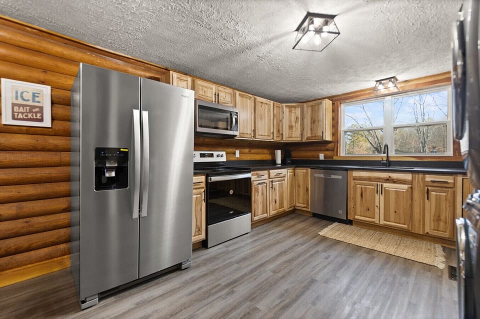 Spacious, fully equipped kitchen with modern stainless steel appliances, ample counter space, and stunning natural wood cabinetry. Perfect for cooking meals during your stay!