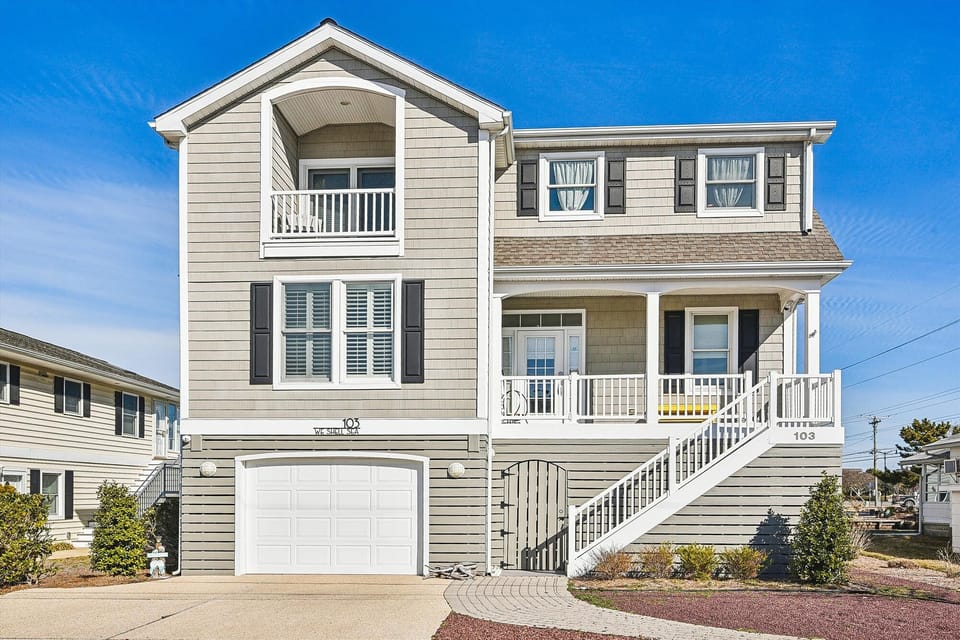 Modern beach house with multiple balconies and coastal charm in a quiet neighborhood setting.