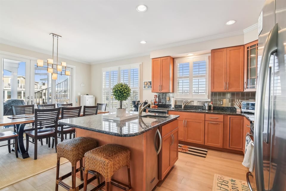 Picture yourself preparing meals in this bright, well-appointed kitchen with gleaming granite counters, stainless steel appliances, and plenty of cabinet space. The center island invites casual dining while natural light pours through plantation shutters.
