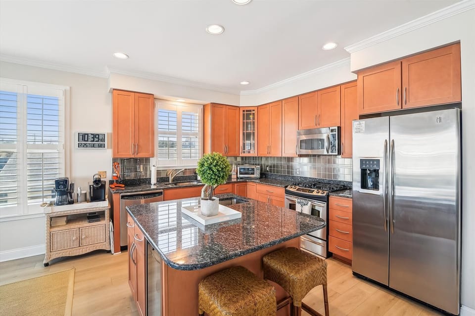 Your spacious, sunlit kitchen awaits with gleaming granite countertops, stainless appliances, and a charming island—perfect for preparing meals and gathering with loved ones.