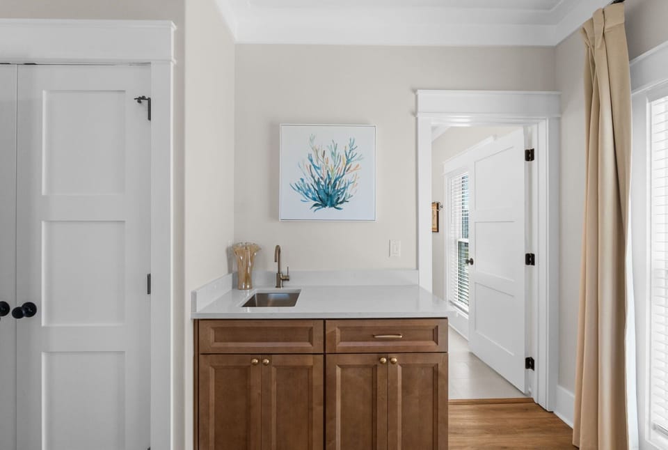 Your own wet bar with a sleek sink and elegant wood cabinetry makes mixing drinks or prepping snacks a breeze in your private retreat.