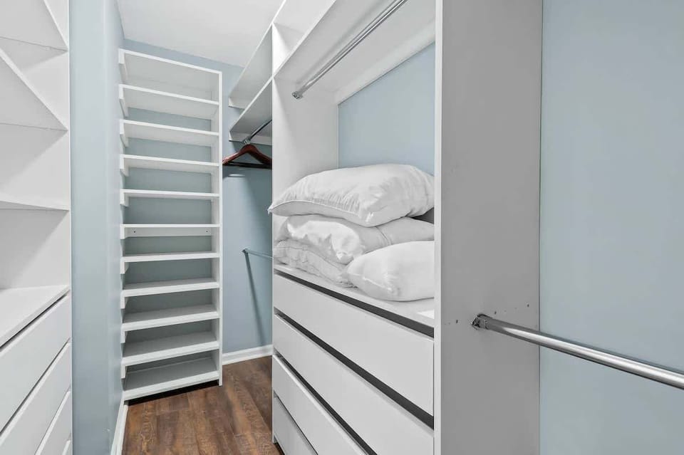 Huge walk in closet with plenty of storage and extra pillows.