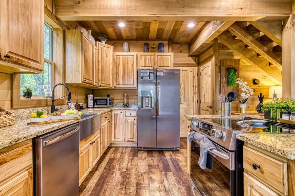 Cook like a pro in the gourmet kitchen with stainless steel appliances, granite countertops, farmhouse sink, and modern stove—your culinary retreat in the Smokies.