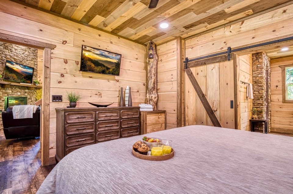Relax in the luxurious king bed of this romantic main-level retreat, complete with rustic tree-trunk accents, a dresser, HD TV, and private ensuite bathroom—your cozy Gatlinburg hideaway awaits.