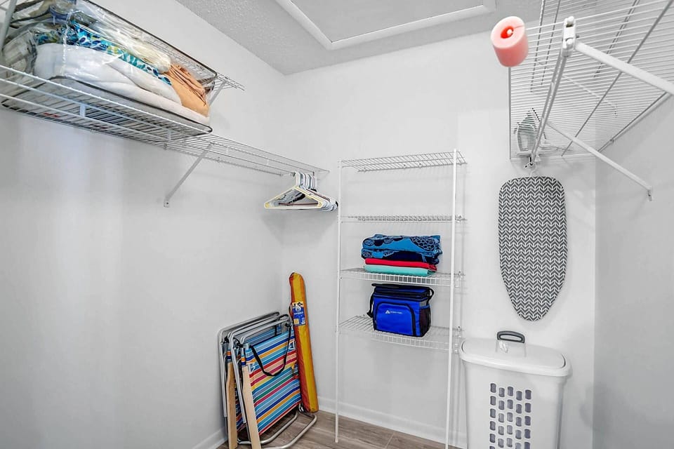 Master bedroom walk in closet with beach supplies