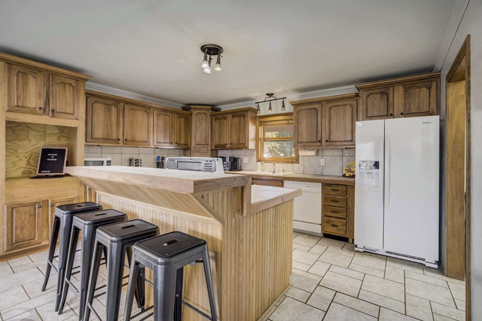 A spacious and well-equipped kitchen with ample counter space, modern appliances, and a breakfast bar for casual dining.