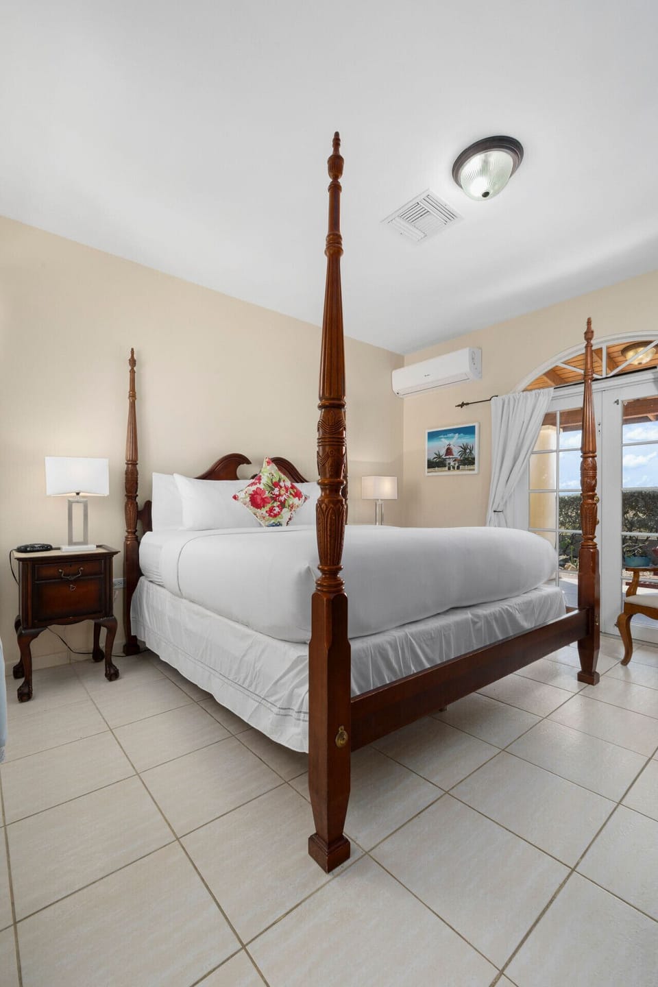 Relax in this charming four-poster bedroom, featuring vibrant floral accents and cozy comforts for your perfect escape!