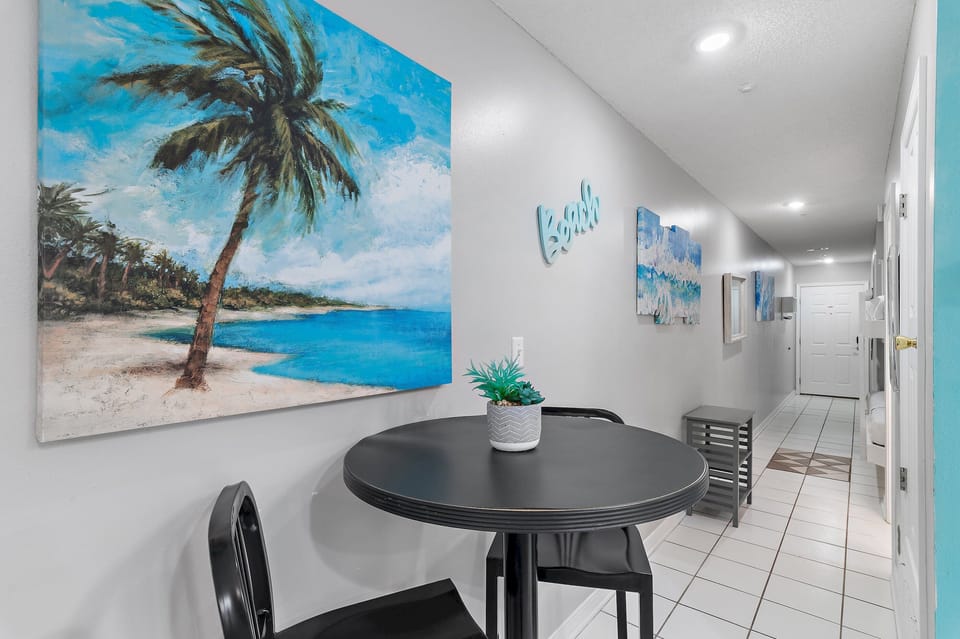 A bright dining nook with cheerful coastal art.