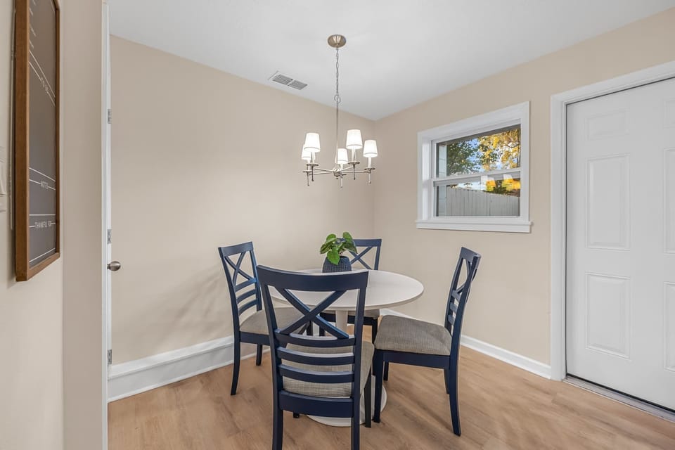 Cozy dining area with navy chairs and natural light from the window