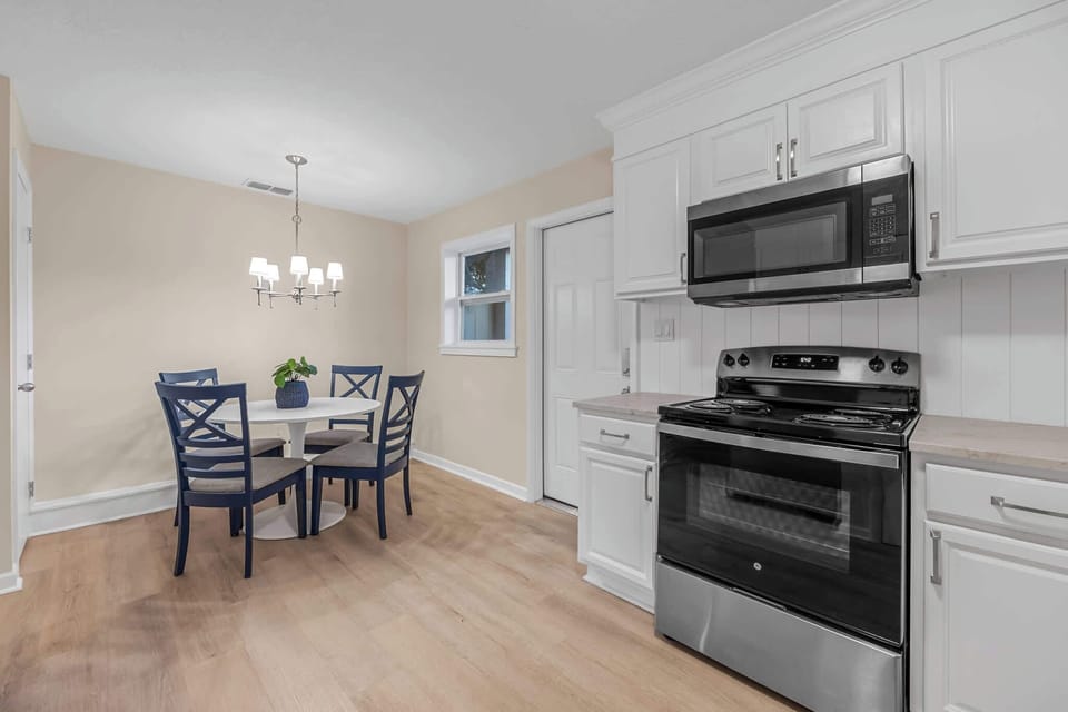 Modern kitchen with stainless steel appliances and a cozy dining area.
