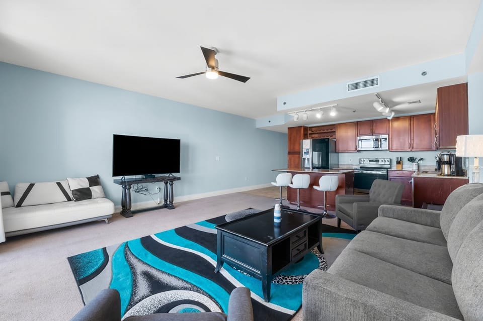 Spacious living area with modern kitchen and vibrant blue accent wall.